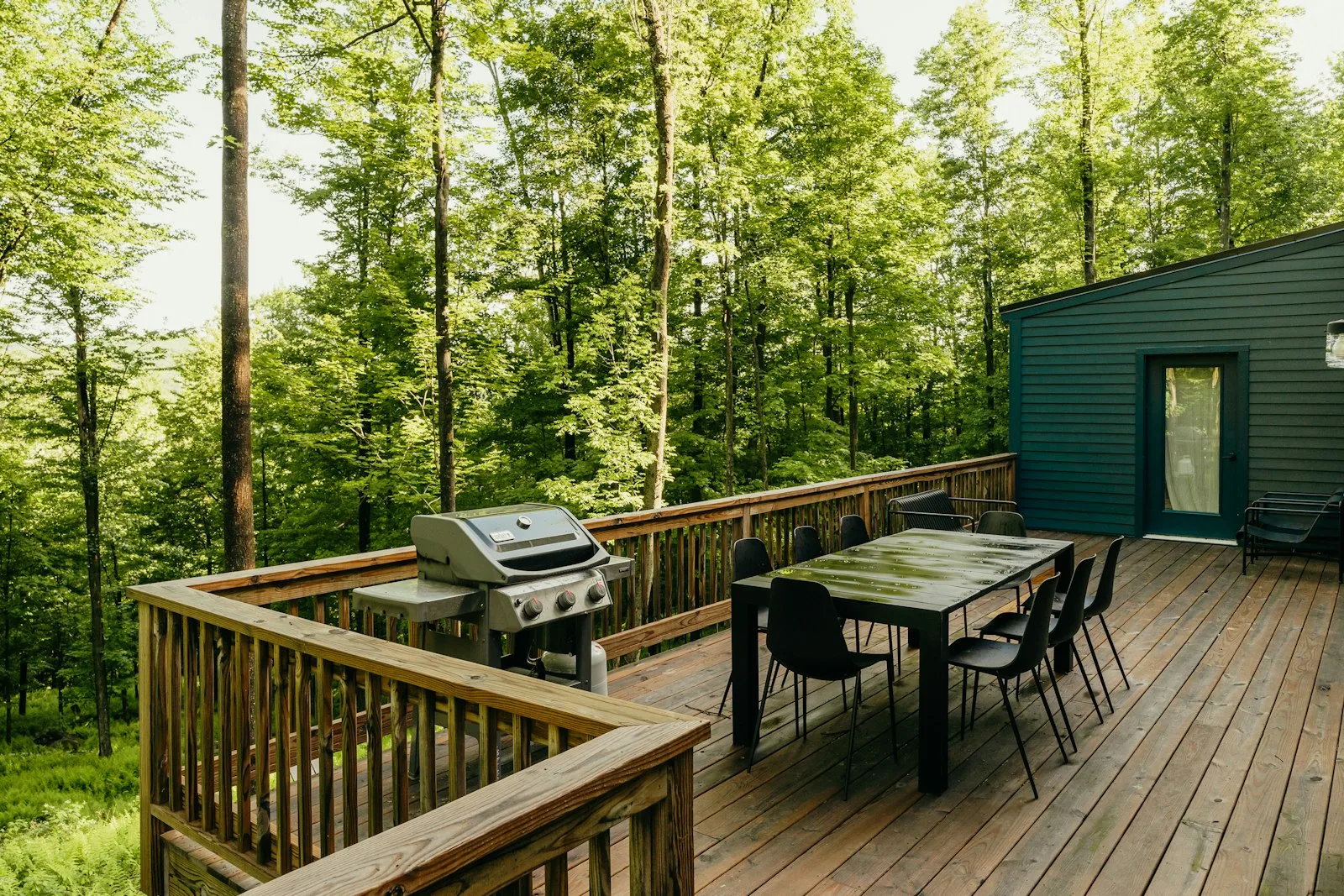 Wooden deck with a dining table, chairs and barbecue set up for entertaining