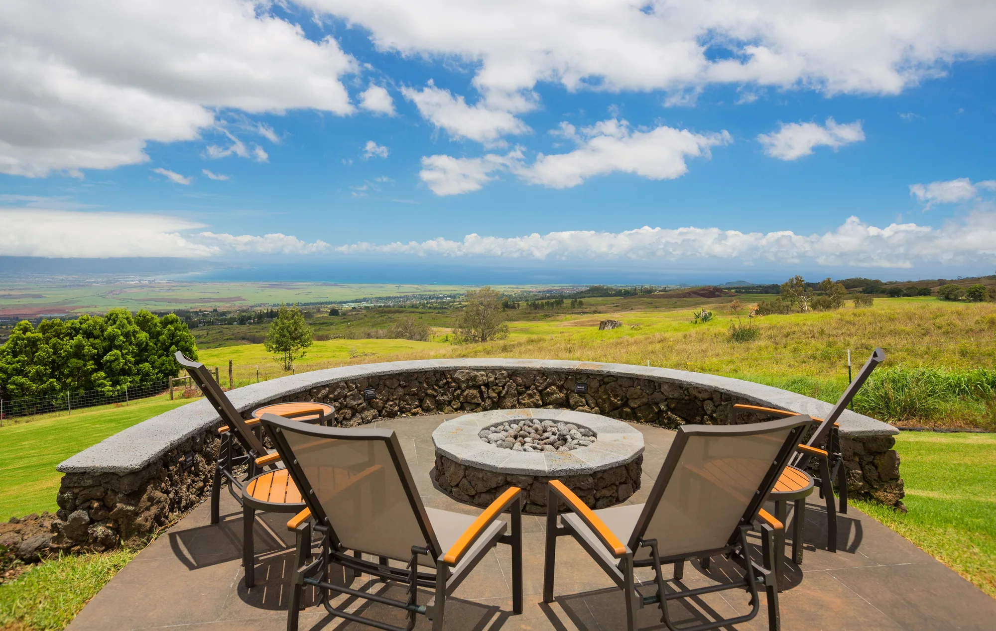 Stone-walled fire pit seating area overlooking a rural valley view