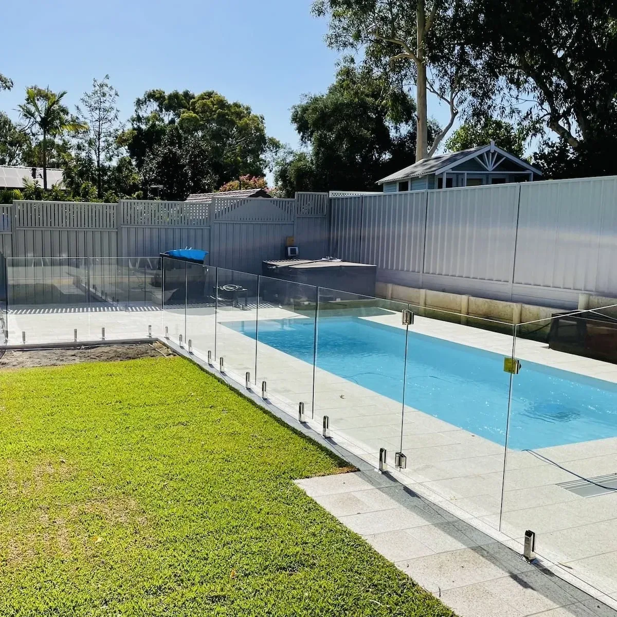 Pool and paved surrounds under construction with glass pool fencing