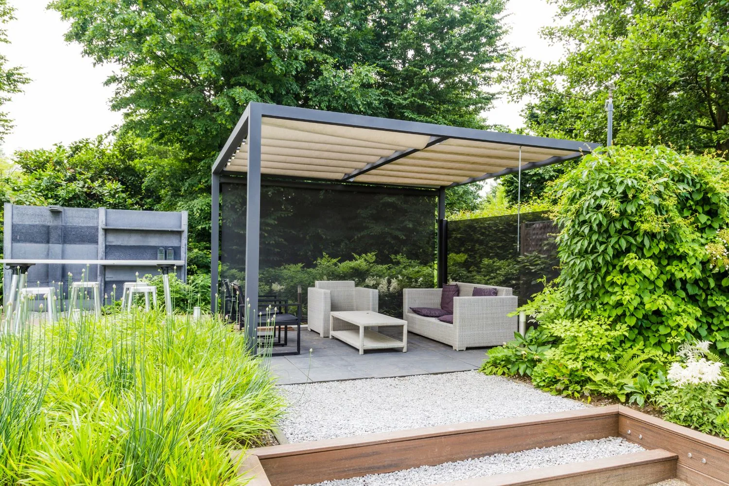 Modern pergola structure with a retractable louvre roof over a lounge setting